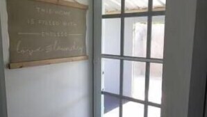 Habitació d'angle amb una porta de vidre translúcid, una pissarra amb anotacions i un sòl amb motius.