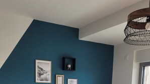 Una sala moderna con un sofá gris, una mesa de centro y una pared azul de acento.