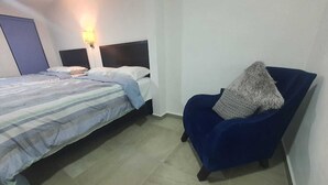 Ein Schlafzimmer mit einem Bett, einem Sessel und einem Nachttisch.