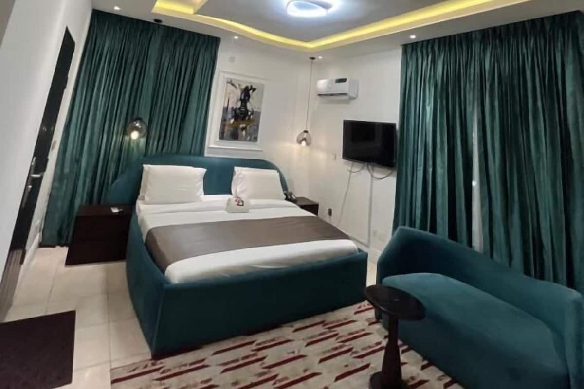 Een moderne slaapkamer met een bed, een bank en een televisie.