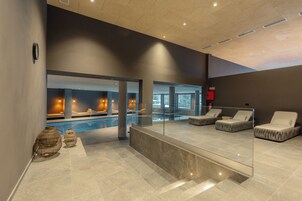 Una piscina cubierta, tumbonas