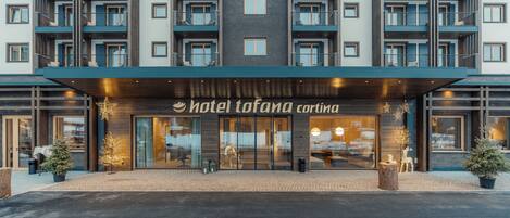 A multi-story hotel with balconies, a central entrance, and a sign reading "Hotel Tofana Carintia".