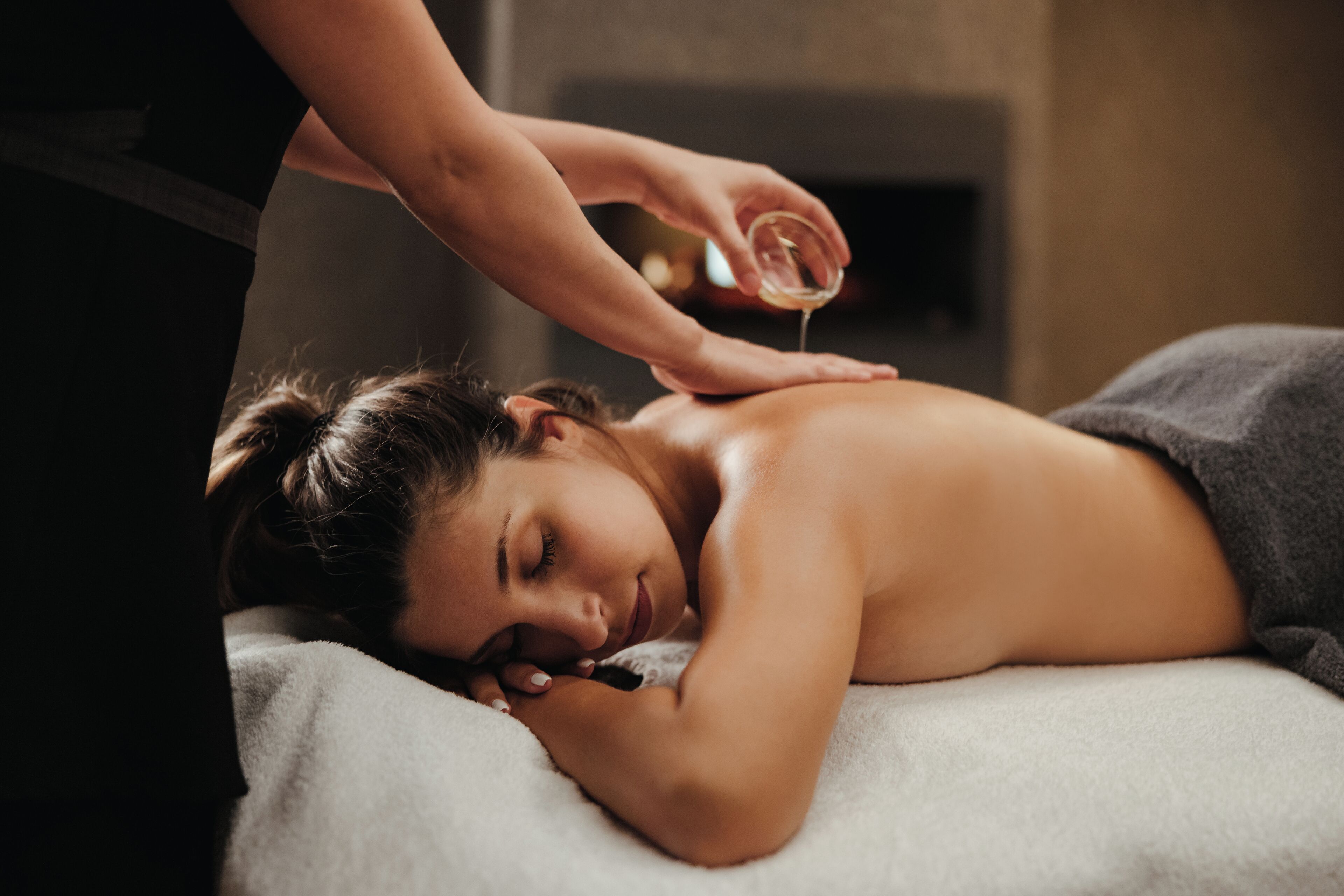 A person receiving a massage in a room with a massage table and a towel.