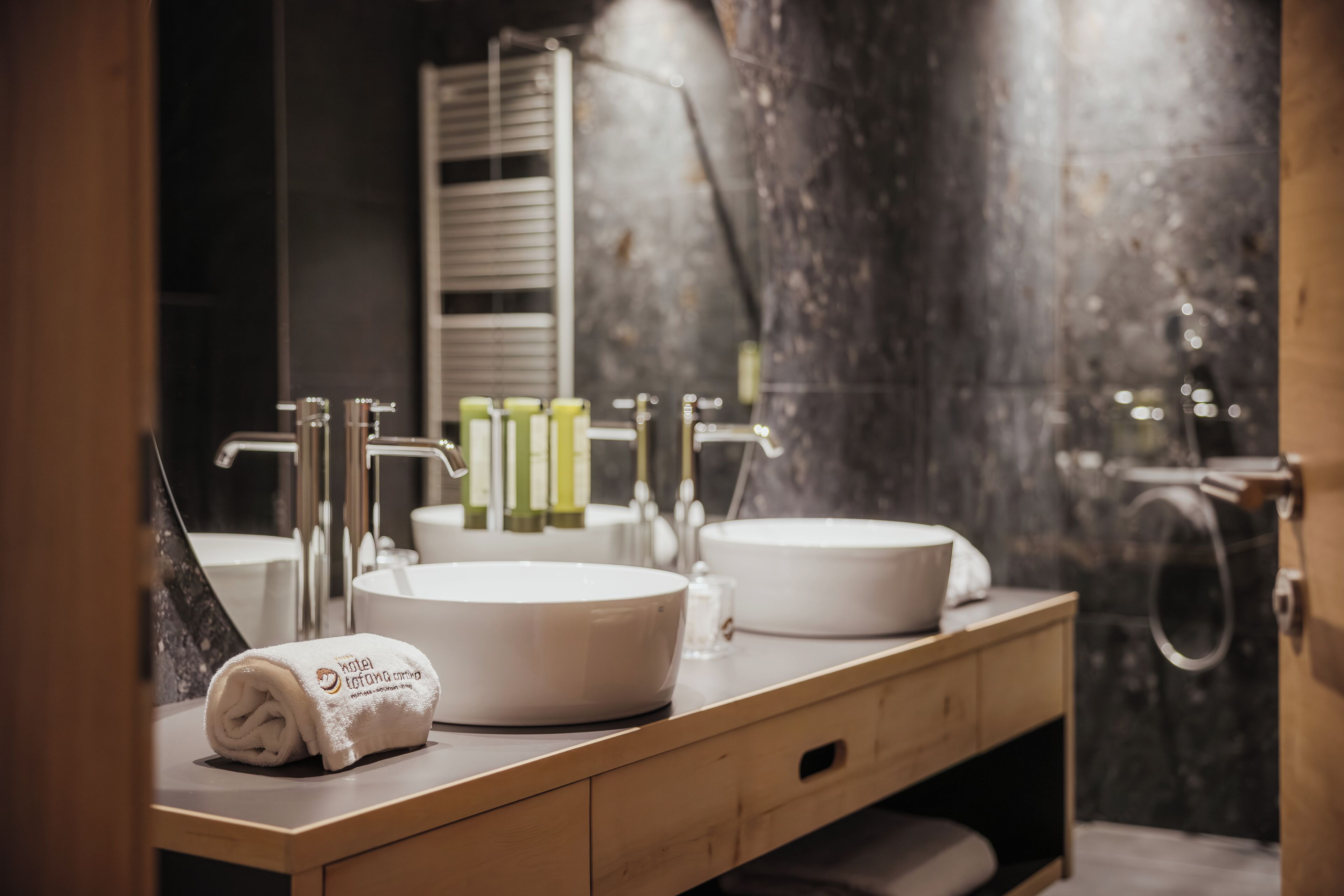 A bathroom with two sinks, a towel, and toiletries.