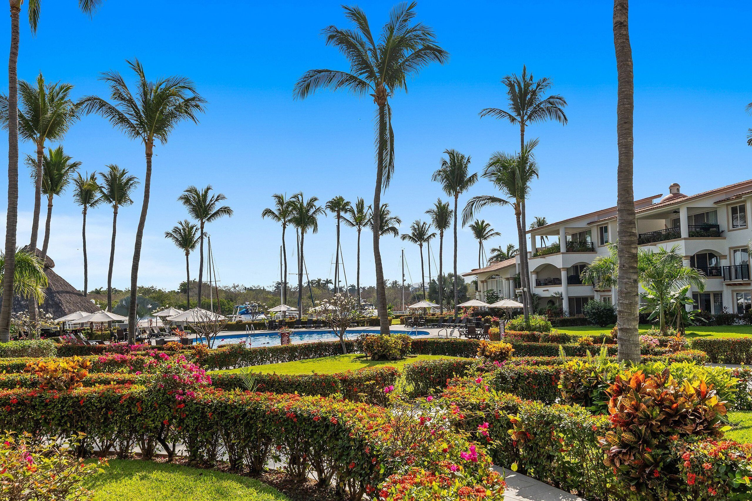 Ein Resort mit Pool, Palmen und gepflegten Gärten.