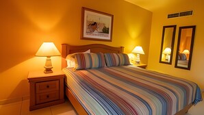 A hotel room with a bed, two bedside tables with lamps, a small drawer unit, and a framed picture on the wall. - Condominio 1HAB/Balcón - Grand Marina Villas (Nuevo Vallarta)