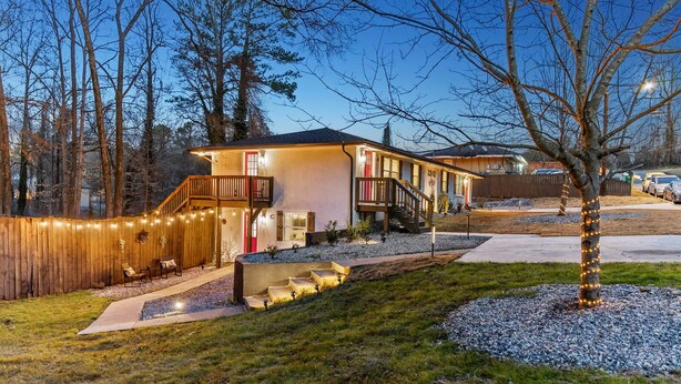Une maison à deux étages dotée d’un balcon, d’un patio couvert et d’une allée bien éclairée.