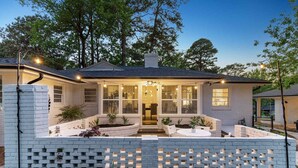 Une maison avec une façade en briques, un patio couvert et une entrée bien éclairée.