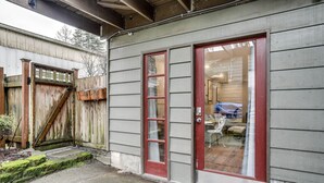 Un bâtiment avec une porte rouge et un portail en bois.