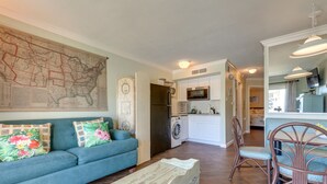 A living room with a sofa, a coffee table, and a map on the wall. - Gulf-View Balcony, Near Beach! Galveston Retreat (Galveston)