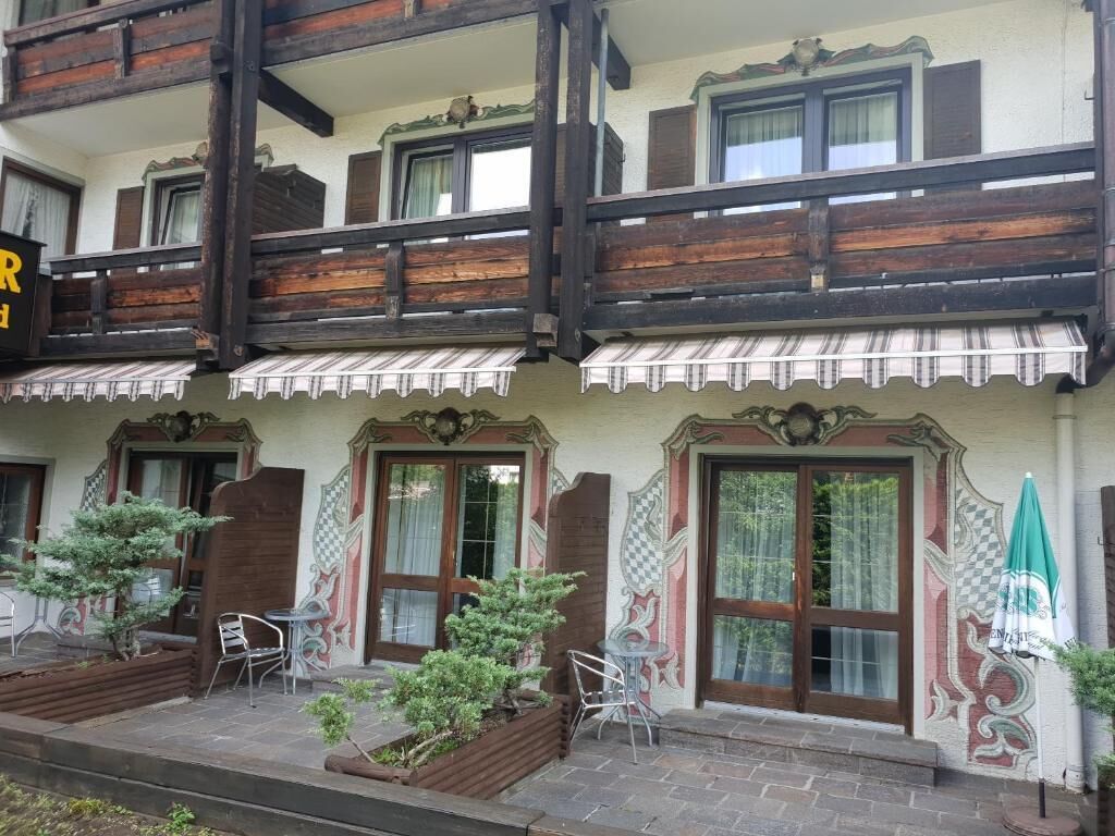 Un edificio tradicional con balcones de madera, ventanas amplias y zonas de estar al aire libre.