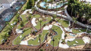 Een golfbaan met meerdere greens, waterhindernissen en een clubhuis.