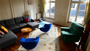 Ein Wohnzimmer mit einer Couch, zwei Sesseln, einem Couchtisch und einem Teppich.