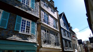 Eine enge Straße mit traditioneller europäischer Architektur, mit steinernen Fassaden und Fensterläden.