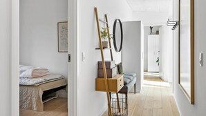 A modern bedroom with a bed, bedside table, and a mirror. - Cozy home in Aakirkeby with WiFi (Aakirkeby)