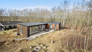 A modern house with a large deck, surrounded by a forest. - Cozy home in Aakirkeby with WiFi (Aakirkeby)