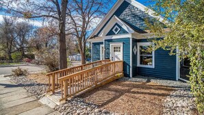 A two-story house with a blue exterior, a wooden deck, and a gravel driveway. - Downtown Loveland Bungalow, charming, historic 2BR recently remodeled gem. 

 (Loveland)