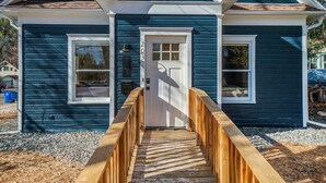 A small house with a wooden deck leading to a white door, two windows, and a mailbox. - Downtown Loveland Bungalow, charming, historic 2BR recently remodeled gem. 

 (Loveland)