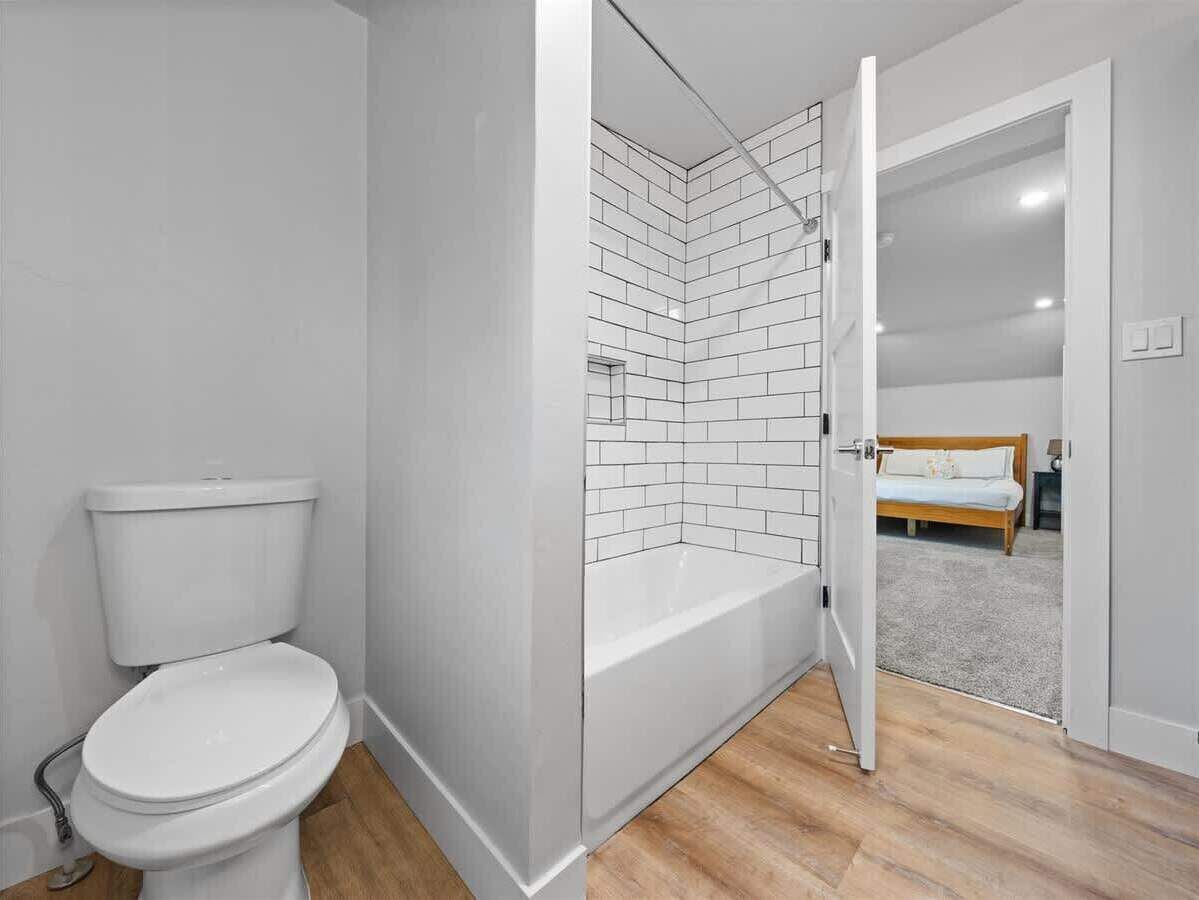 A modern bathroom with a toilet, shower, and bathtub.