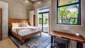 Un dormitorio con una cama de madera, un escritorio y un amplio ventanal con vistas a zonas verdes.