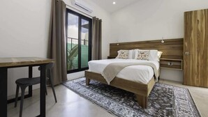 Un dormitorio con una cama, un escritorio y una silla.