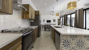 Una cocina moderna con armarios de madera, una estufa de acero inoxidable y una isla grande con un lavamanos.