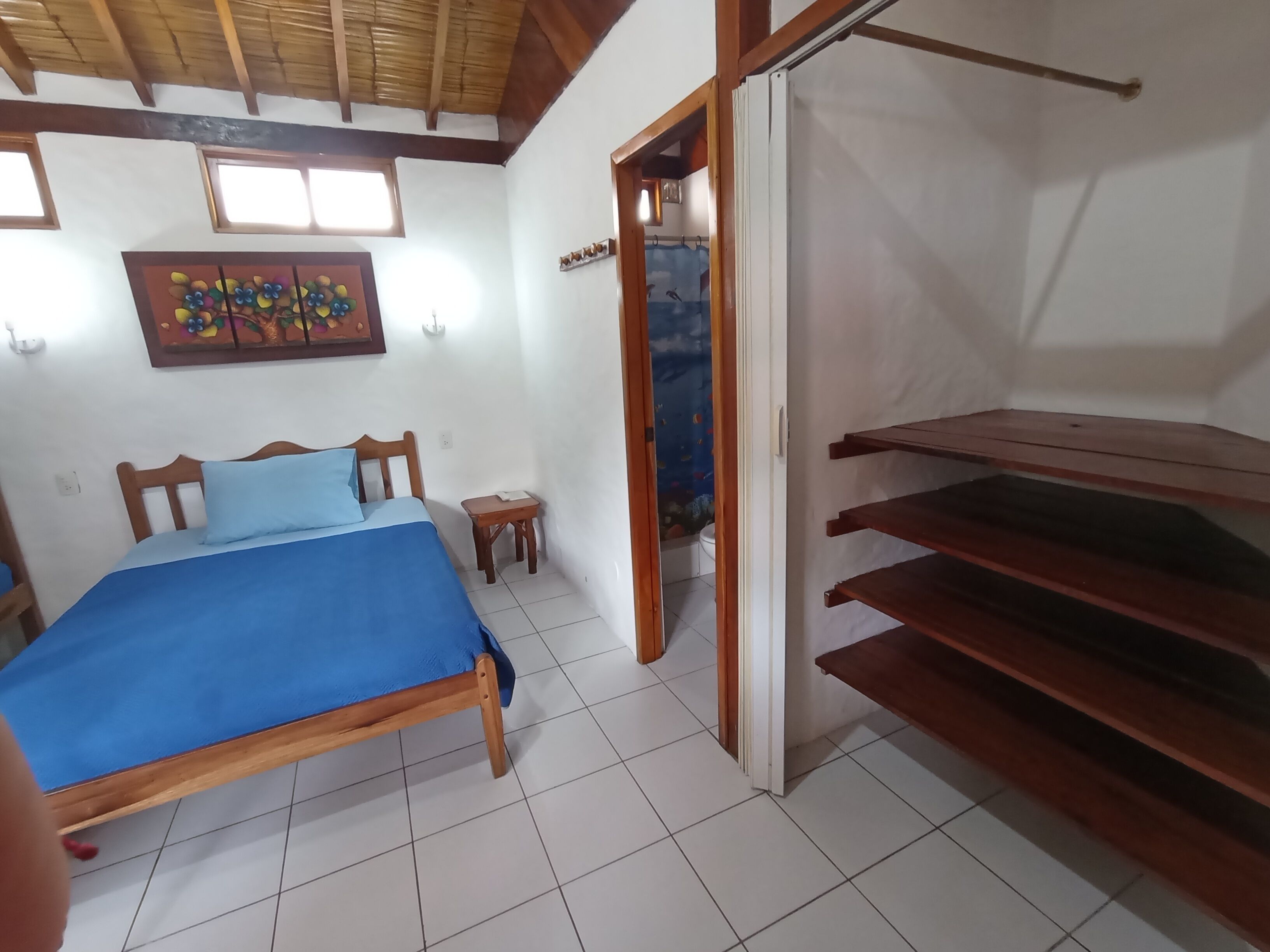 Une chambre à coucher avec un lit, une petite table et une armoire.
