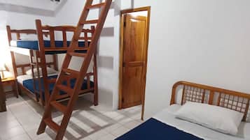 A room with bunk beds, a wooden ladder, a door, and a bed with a blue mattress.