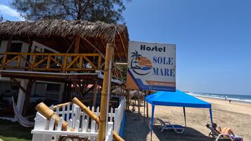 A beachside hostel with a sign advertising 'Hostel Sole Mare'.