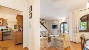 Un vaste espace de vie comprenant un canapé et des fauteuils, une cuisine avec des meubles en bois et un escalier menant à un autre niveau.