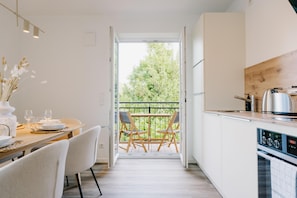 Eine moderne Küche mit Essbereich und Blick ins Freie, inklusive eingebautem Ofen.