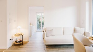 En moderne stue med sofa, lampe og et lille bord.