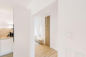 Una cocina moderna con encimera de madera, una banca y una lámpara colgante.