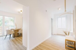 Une pièce spacieuse comprenant un coin repas, de grandes fenêtres et un plancher en bois.