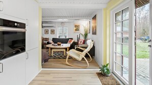 A compact living space with a kitchenette, a dining area, and a seating area with a rocking chair.