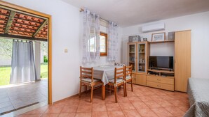 A dining area with a table and chairs, a TV, and a cabinet with glass doors. - Gorgeous home in Valbandon with WiFi (Valbandon)