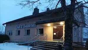 Un edificio con un letrero que dice "Bed & Breakfast" y una escalera que lleva a la entrada.