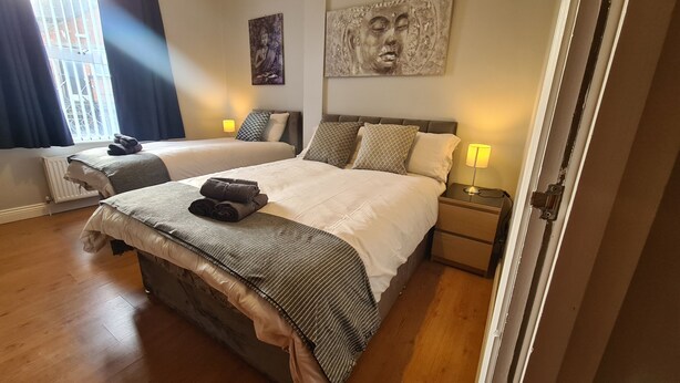A double room with two beds, each with a headboard, bedside tables, and lamps. - Waterworks En Suite Rooms with Private Living Room (Belfast)