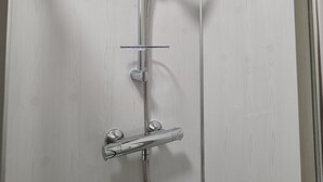 A glass-enclosed shower with a handheld showerhead and a wall-mounted faucet. - Waterworks En Suite Rooms with Private Living Room (Belfast)