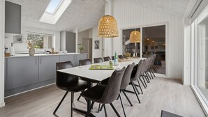 A modern kitchen with grey cabinets, a white countertop, and a skylight.