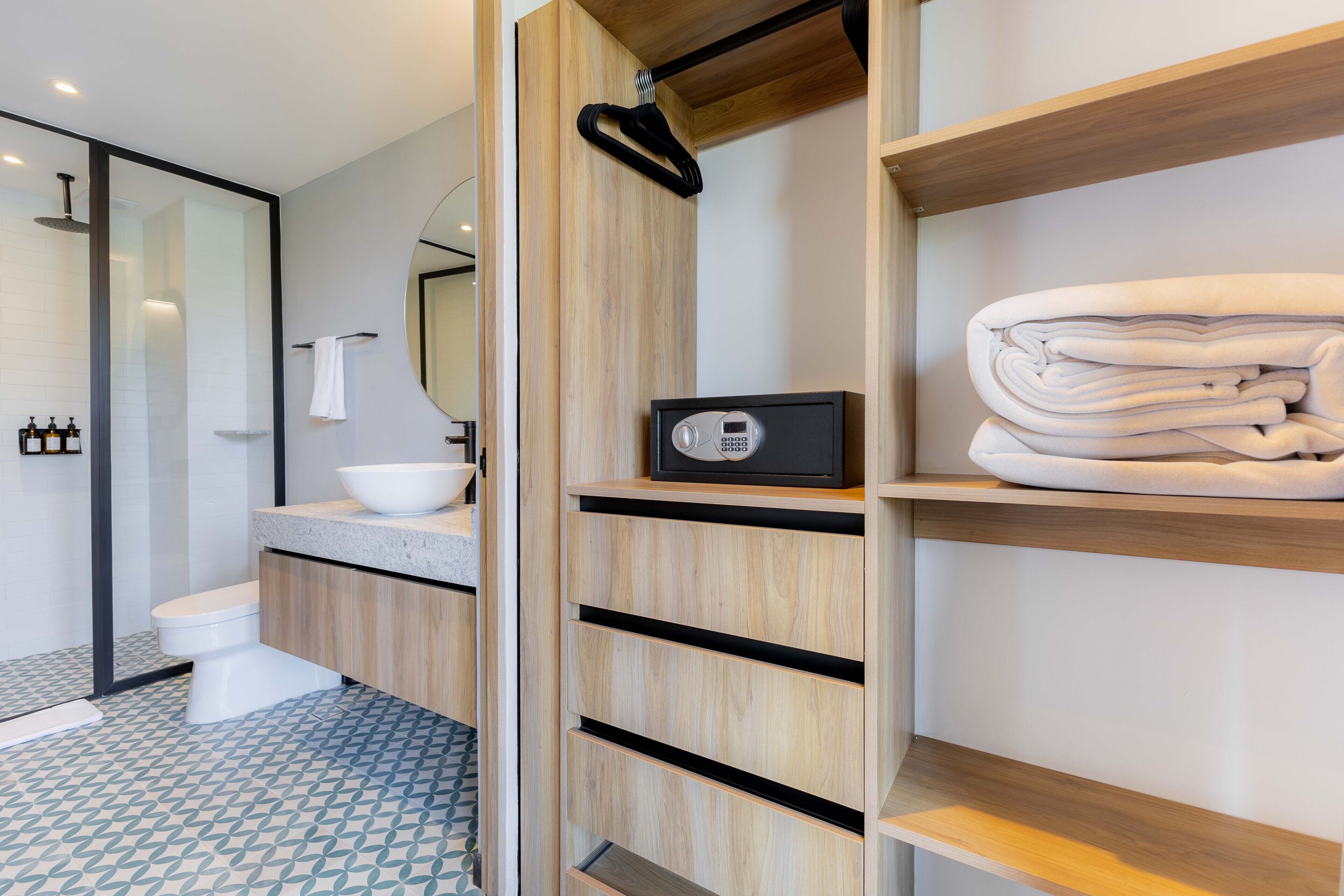 A modern bathroom with a toilet, sink, and towel storage.