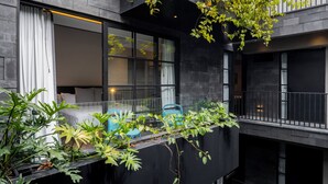 A modern building with a balcony featuring plants and blue chairs. - Park Condesa By Capitalia (Mexico City)
