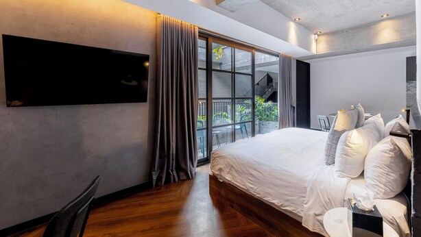 A modern bedroom with a large bed, a flat-screen TV, and a sliding glass door leading to a balcony. - Park Condesa By Capitalia (Mexico City)