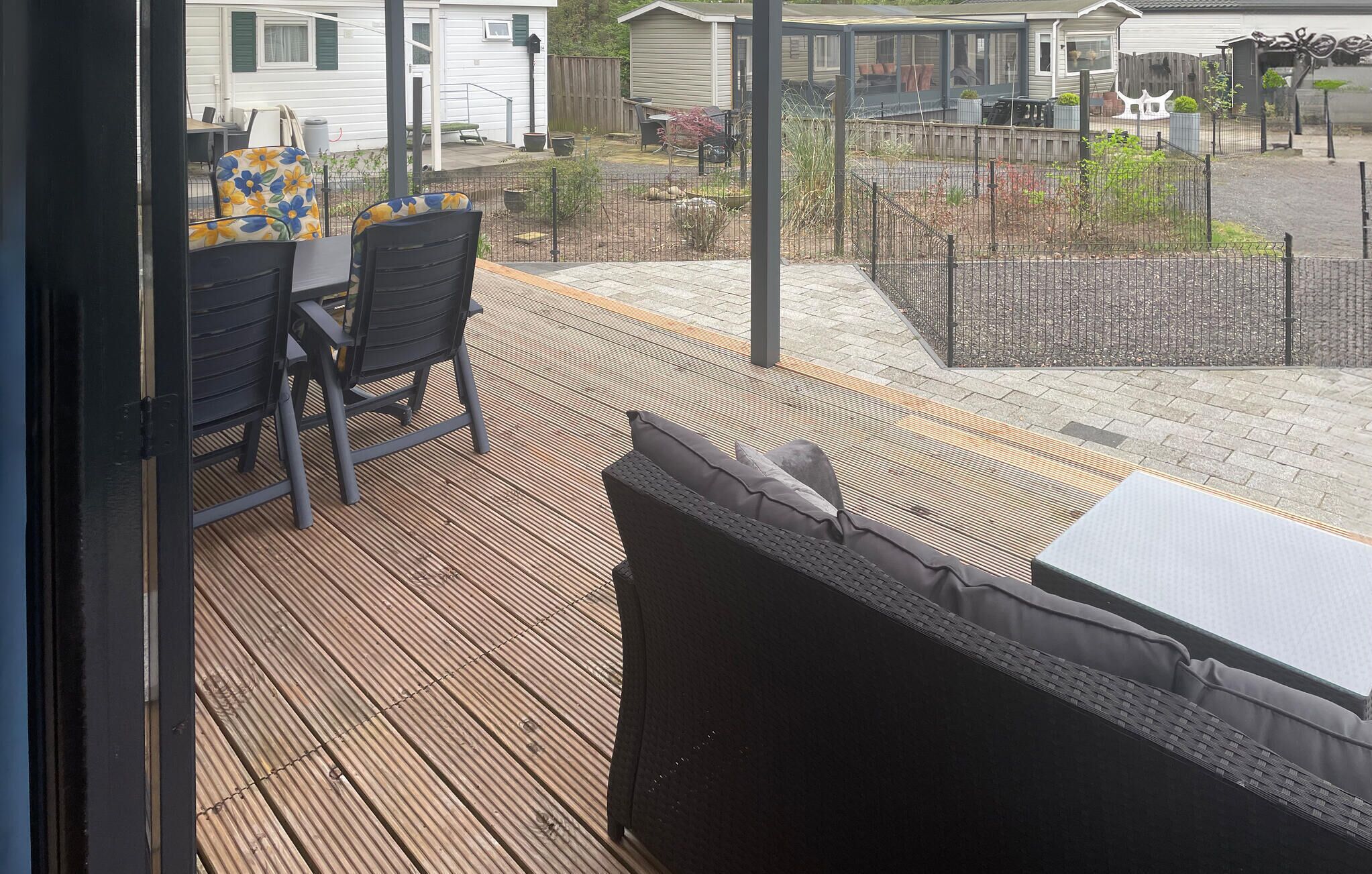 Un patio cubierto con una zona de estar, una mesa y vistas al jardín trasero.