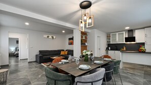 A modern kitchen with white cabinets, a black countertop, and a built-in TV. - Amazing home in Lepoglava with sauna (Lepoglava)