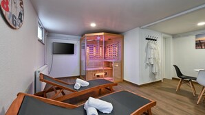 A room with two massage tables, a TV, a sauna, and a clothing rack. - Amazing home in Lepoglava with sauna (Lepoglava)