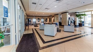 A spacious lobby with a high ceiling, multiple seating areas, and a large window providing natural light. - 3 Pools - Skywalk- 2 Bedroom Updated Condo - Free Daily Activities! (Gulf Shores)
