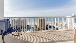 A balcony with a view of the beach and hotel buildings. - 3 Pools - Skywalk- 2 Bedroom Updated Condo - Free Daily Activities! (Gulf Shores)