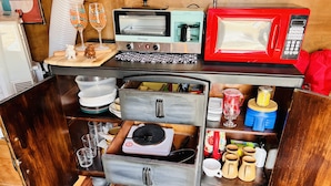 Eine kleine Küche mit Toaster, Mikrowelle und verschiedenen Küchenutensilien.