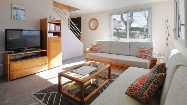 A modern living room with a television, bookshelves, a sofa, and a staircase. - Pretty new and comfortable house between towns and lakes (Voglans)